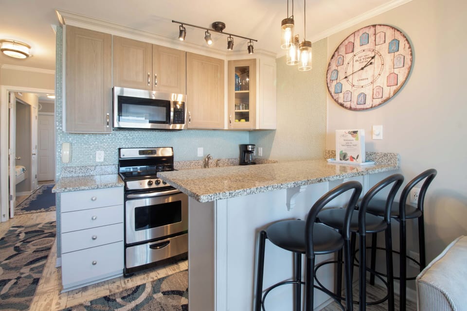Picture yourself brewing morning coffee in this bright, fully-equipped kitchen with granite counters, modern appliances, and a breakfast bar perfect for casual meals with family.