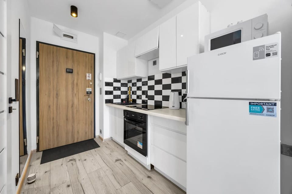 Modern Kitchen Area – Fully equipped with a stove, oven, fridge, microwave, and stylish black-and-white backsplash for your cooking convenience | Book Now with RENTUJEMY.COM