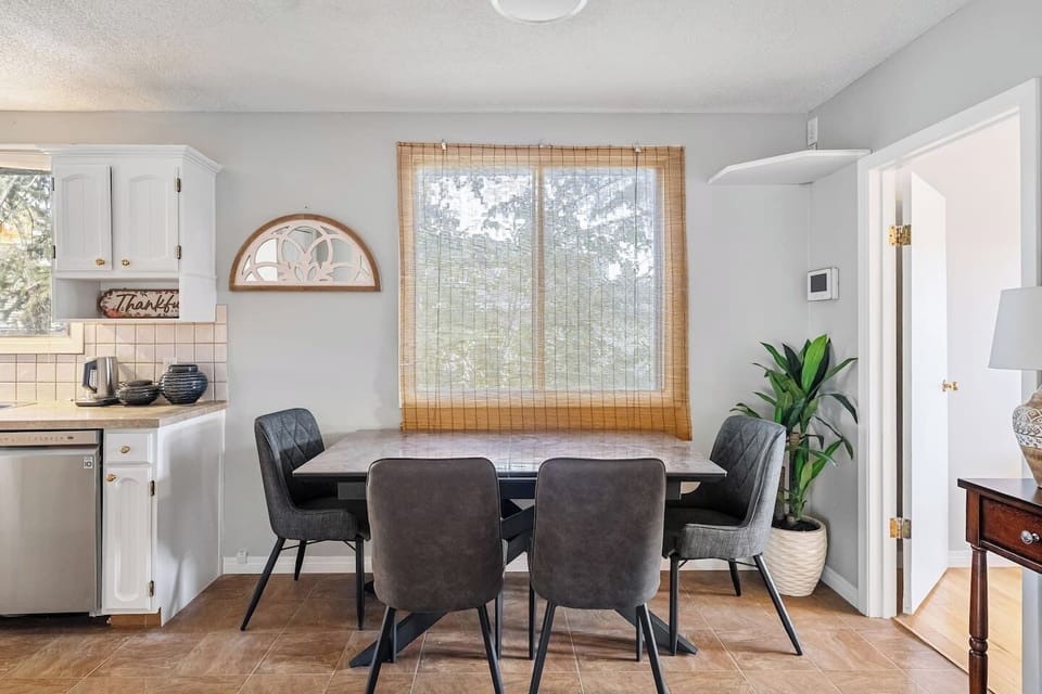 Dining area with seating for 5 at the round table and 4 on the rectangular table two steps above.