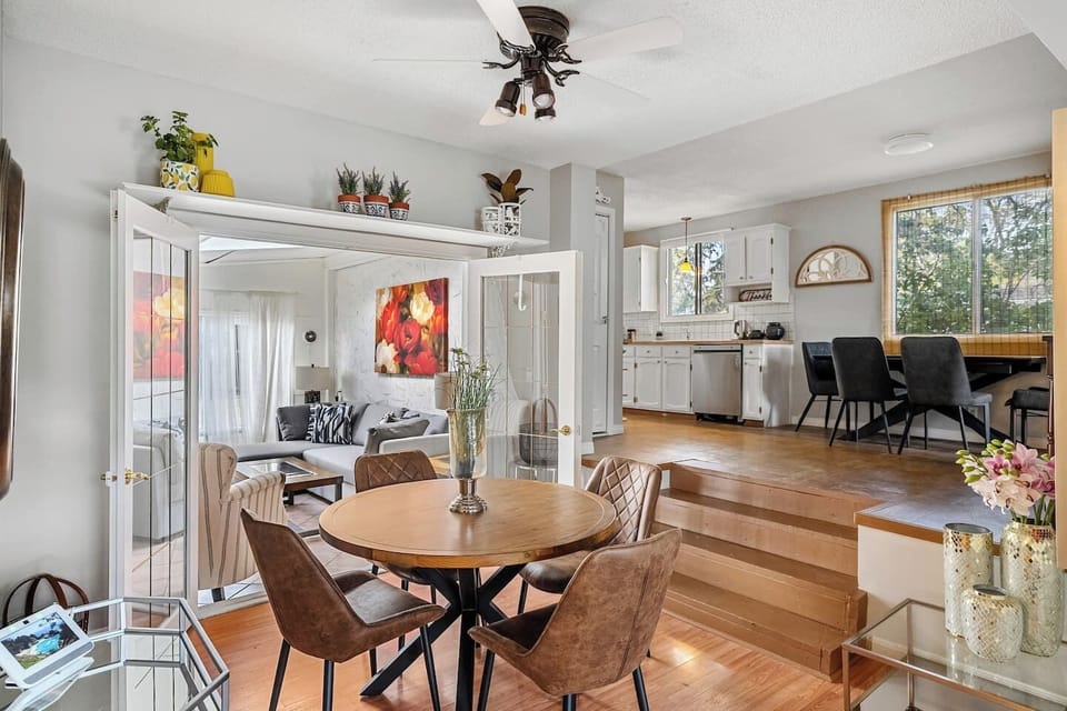 Dining area with seating for 5 at the round table and 4 on the rectangular table two steps above.