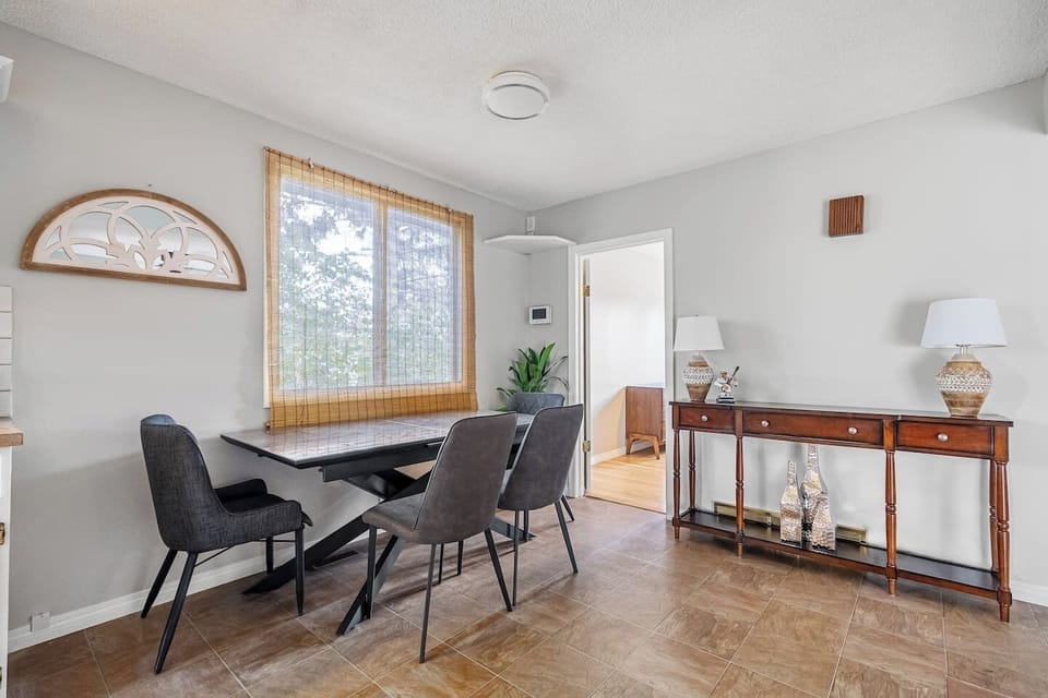 Dining area with seating for 5 at the round table and 4 on the rectangular table two steps above.