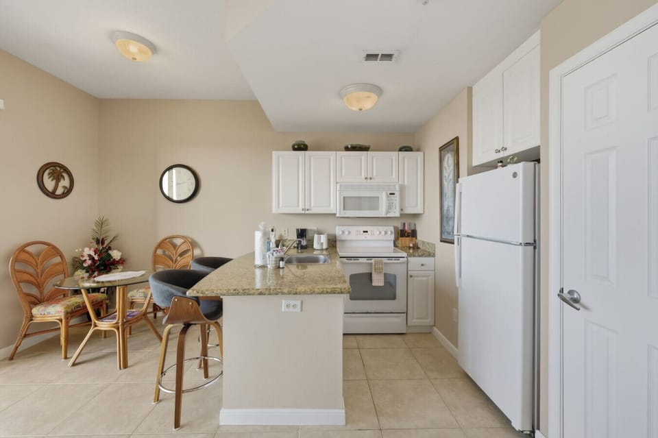 Compact, functional kitchen adjacent to the dining area, featuring modern appliances and a layout ideal for relaxing meals.