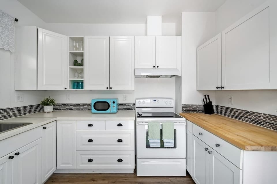 Kitchen with range and butcher-block counter.