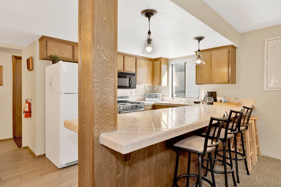 Fully equipped cabin kitchen with ample cabinetry, stove, fridge, microwave, and coffee maker—perfect for cooking meals, morning coffee, and feeling right at home on your stay.