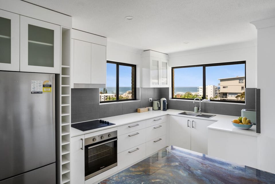 Fully equipped kitchen with island bench and balcony access