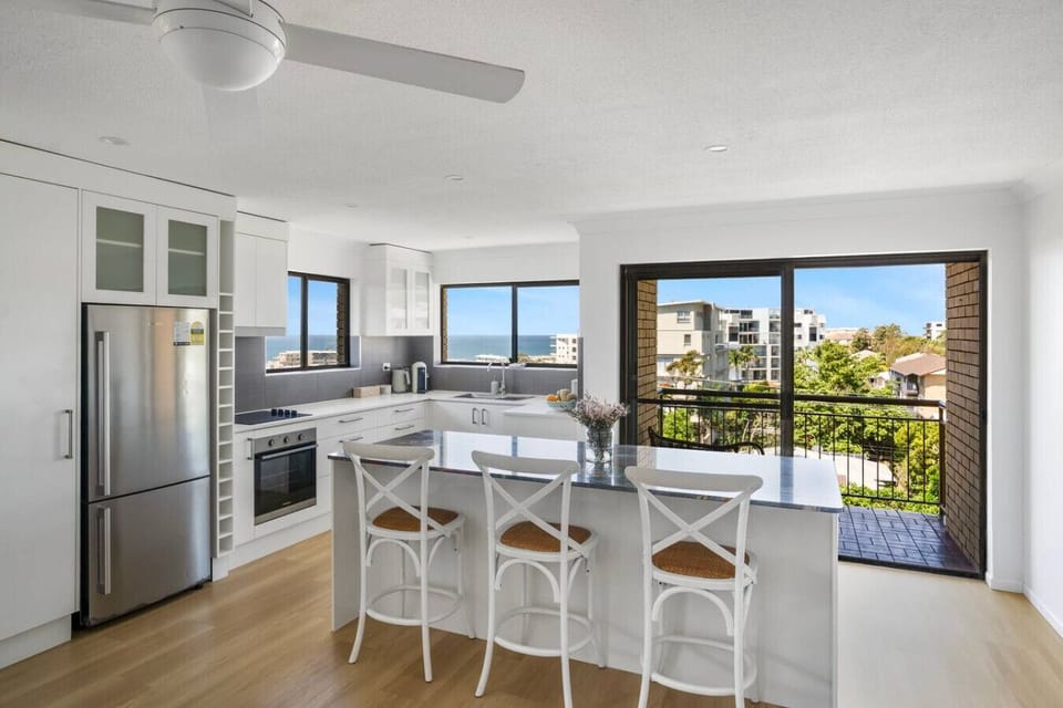 Fully equipped kitchen with island bench and balcony access