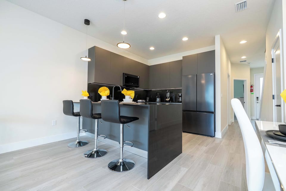 The kitchen island offers additional seating for three, perfect for keeping the cook company or enjoying a casual lunch in this bright, modern space.