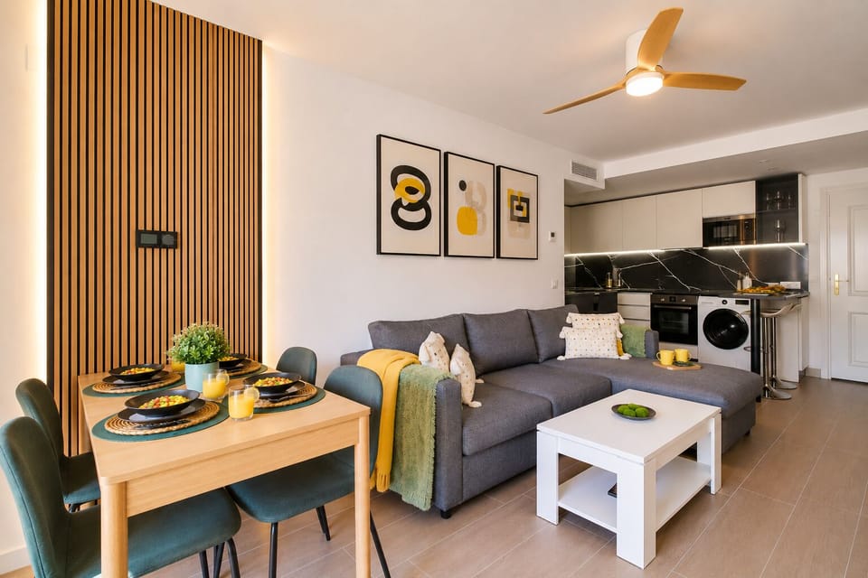 Stylish open-plan living room with a modern kitchen, smart TV, and natural light throughout — ideal for relaxing or sharing a glass of wine after a day by the beach.