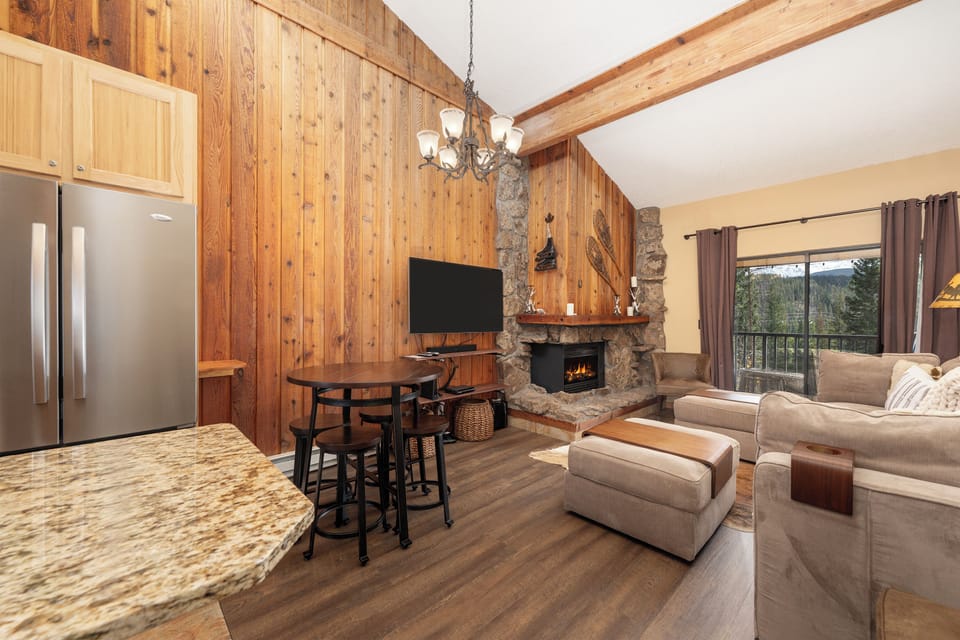 Cozy up in your mountain retreat with warm wood accents, stone fireplace, and forest views through your private balcony.