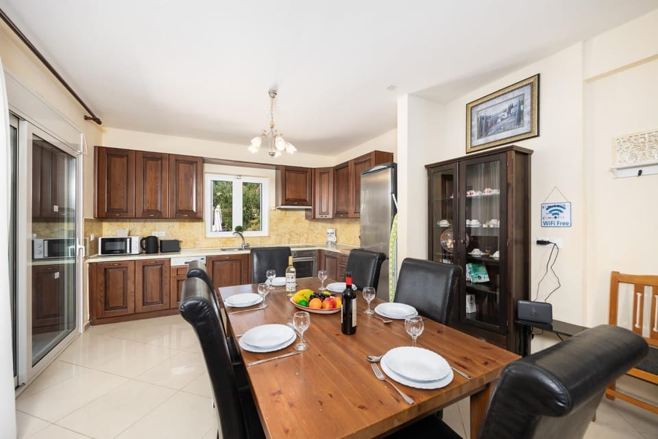 Open-plan living room with sofas, dining area, kitchen, ornamental fireplace, A/C, WiFi internet, and satellite TV