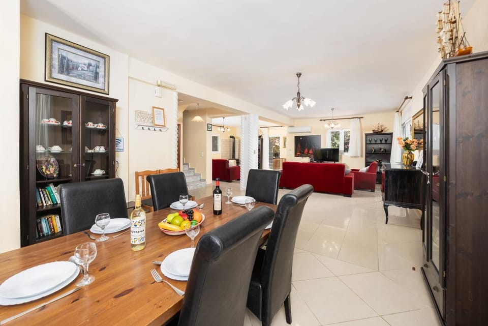 Open-plan living room with sofas, dining area, kitchen, ornamental fireplace, A/C, WiFi internet, and satellite TV