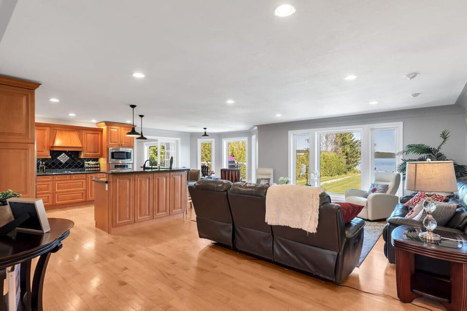 Step into the living room and take in the open layout, comfortable seating, and large windows framing beautiful waterfront views at Romeo Resort.
