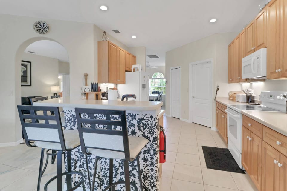 Four barstools at the eating bar separate the kitchen from the family room and breakfast nook.