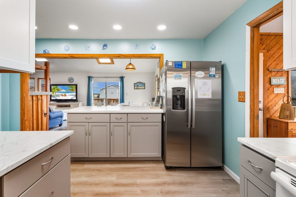 Kitchen: Whip up your favorite coastal meals in the spacious, fully equipped kitchen featuring modern appliances, double ovens, and ample counter space.