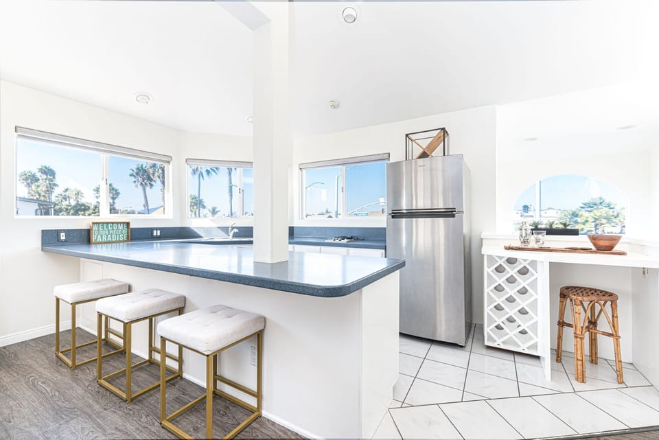 Upper floor kitchenette with barstool seating, ideal for casual meals or morning coffee
                