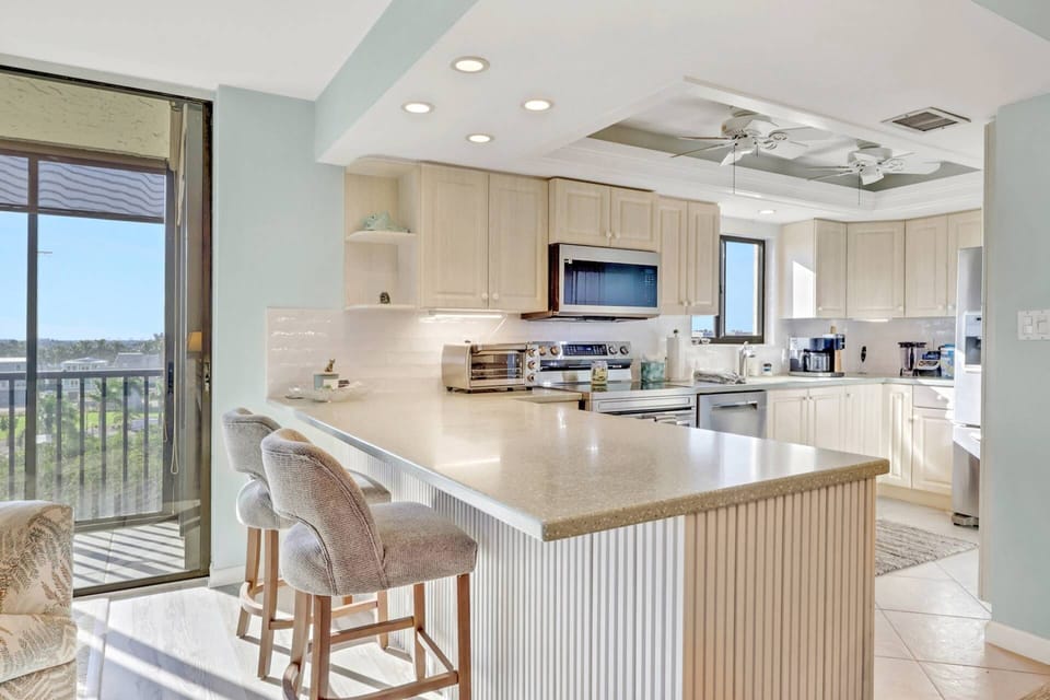 The open kitchen is divided from the main living area by an eating counter with a pair of barstools.