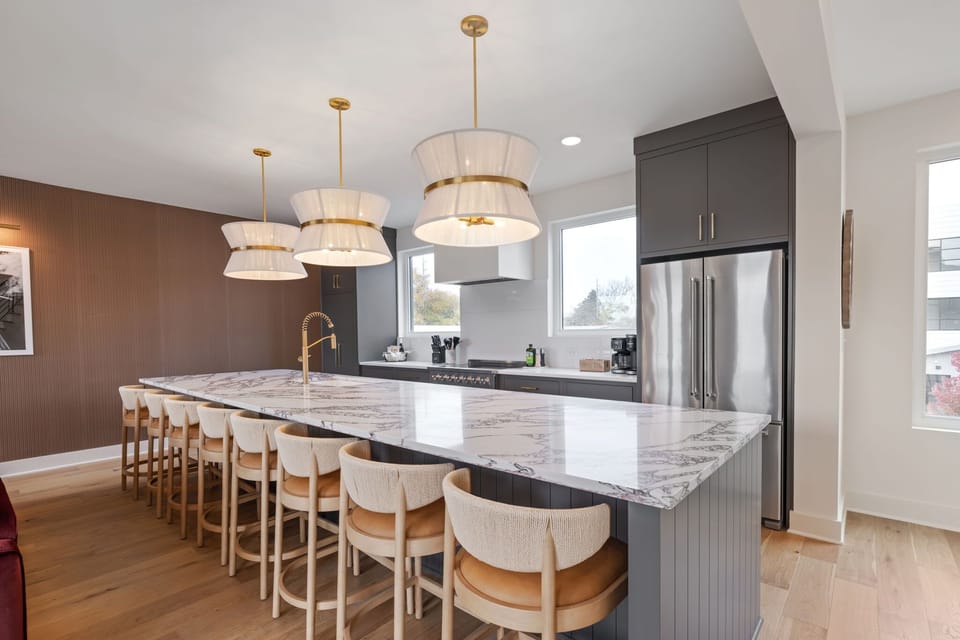 Bright, fully equipped kitchen featuring premium appliances and plenty of seating.