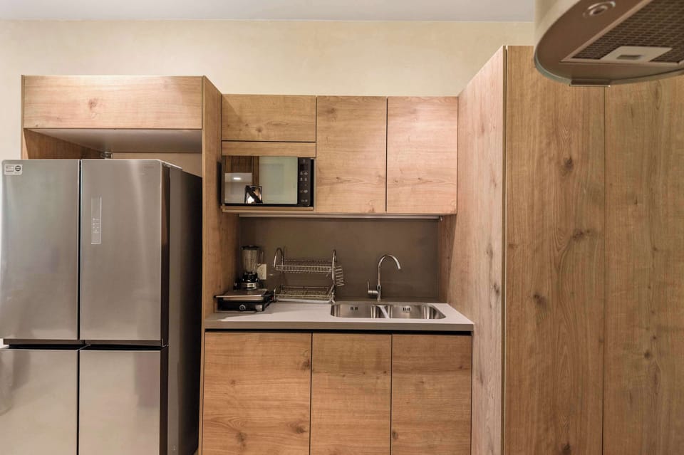 Equipped kitchen with wooden cabinetry and stainless steel appliances