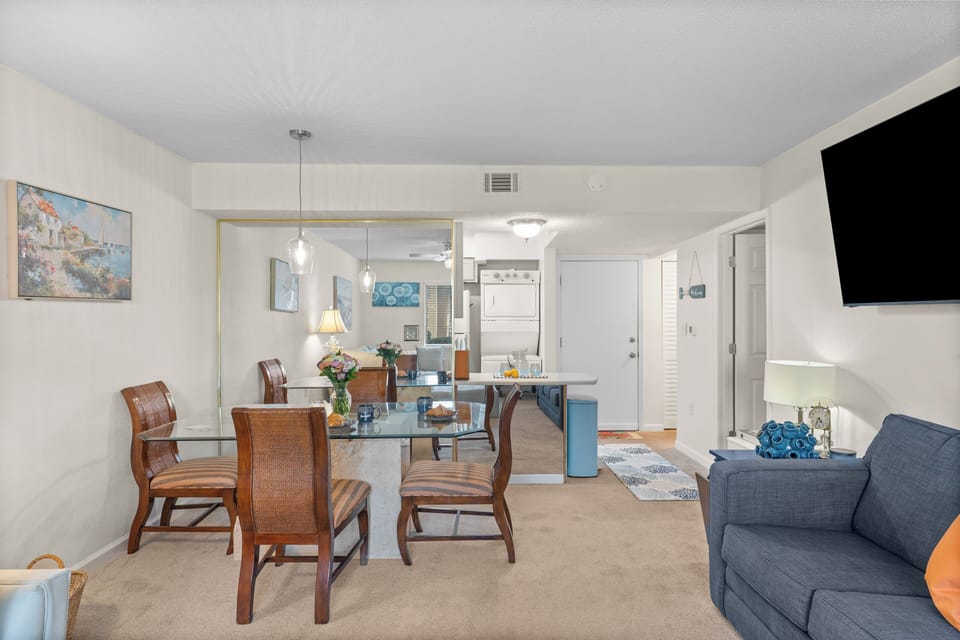 Open concept living room featuring a desk, sectional couch, sleeper sofa and access to the porch. 
