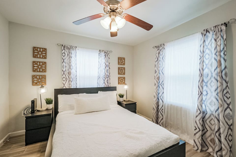 Front House Bedroom with queen sized bed, walk-in closet, hangers, and smart TV