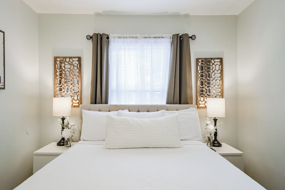 Front House Bedroom with queen sized bed, walk-in closet, hangers, and smart TV