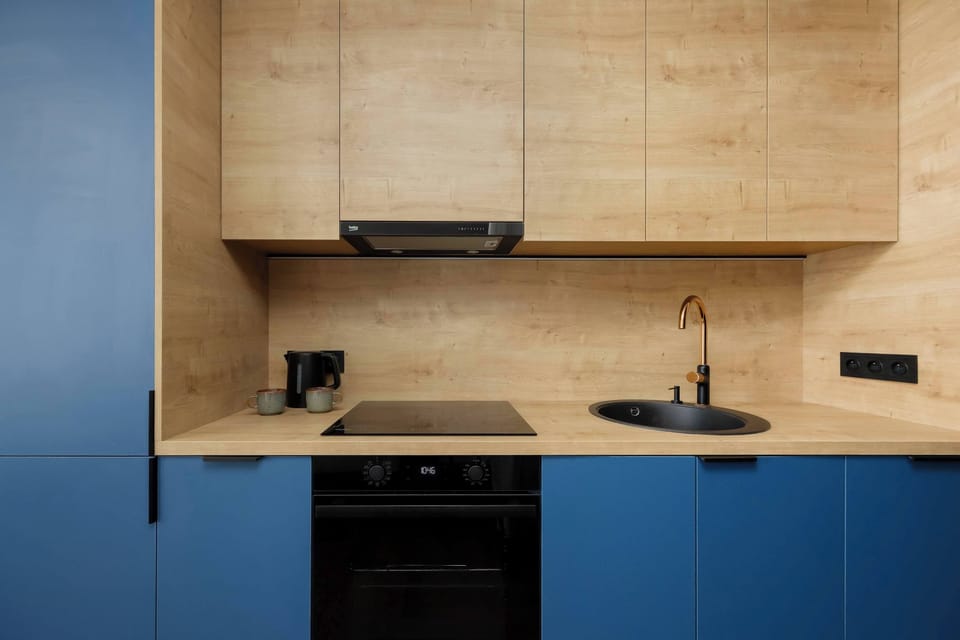 The modern kitchen in shades of blue and wood combines functionality with design, inviting you to cook in a pleasant atmosphere.