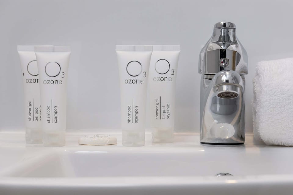 The bathroom's contemporary design includes fresh towels and a hairdryer. 