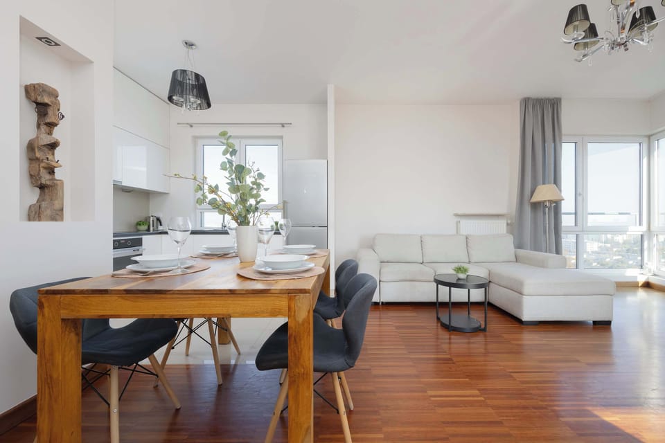 Spacious living and dining area with elegant furniture and wooden floors.
