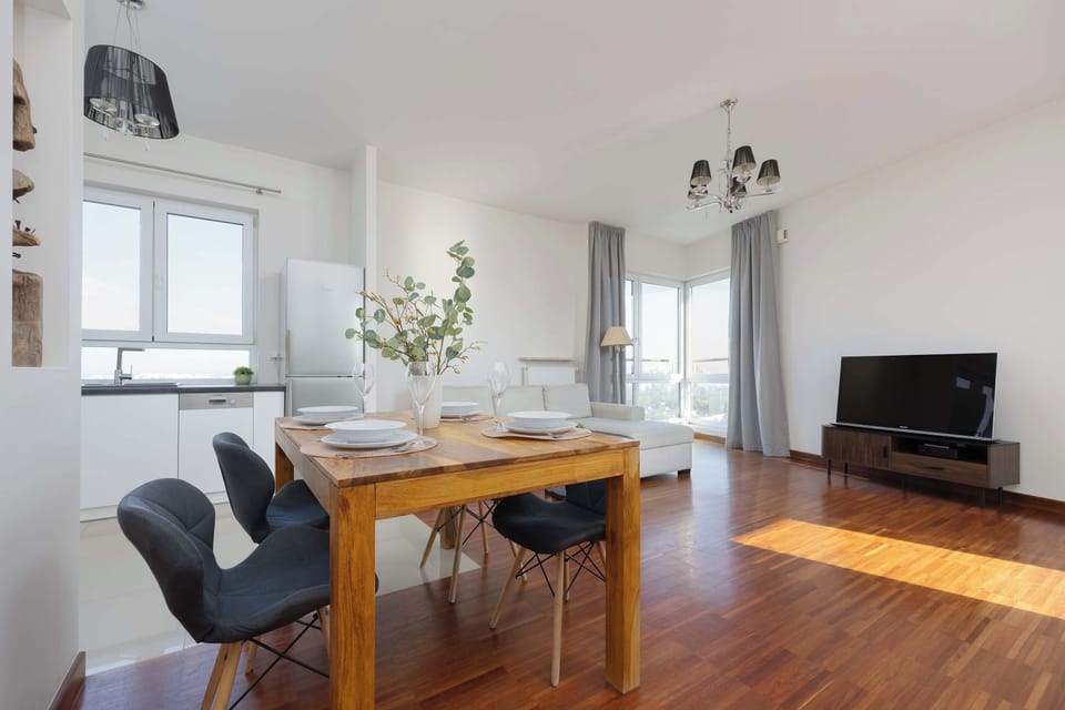 Spacious living and dining area with elegant furniture and wooden floors.