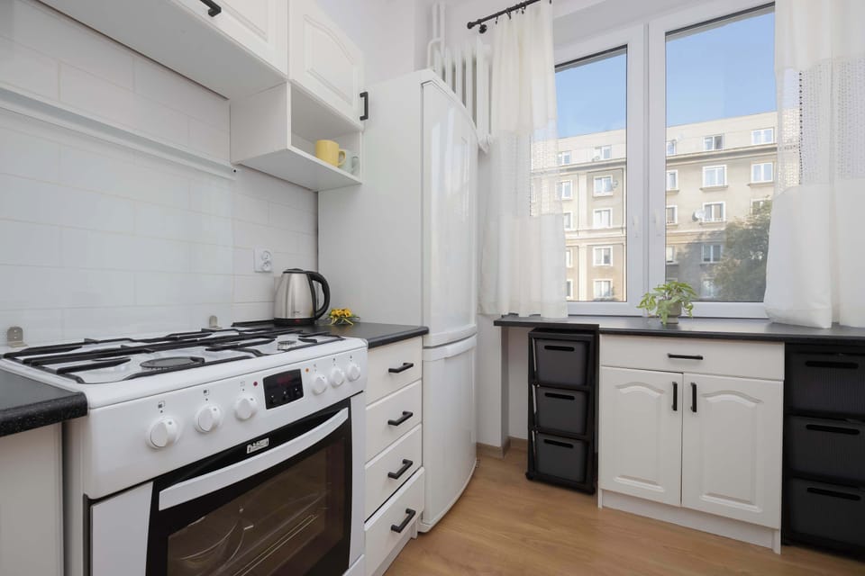 A large kitchen window lets in plenty of light, creating a perfect space for a morning coffee with a city view.