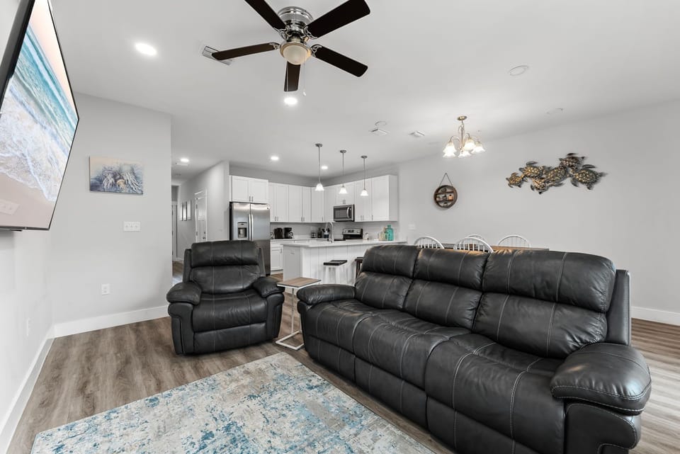 Modern open living area with leather seating and a fully equipped kitchen.