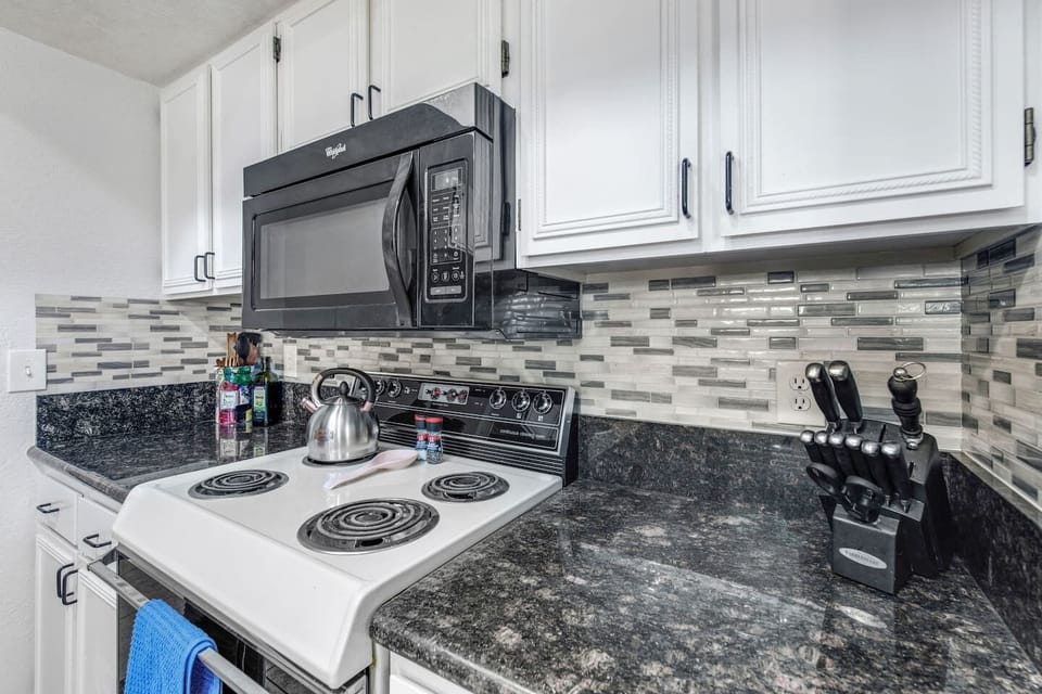 Well-stocked kitchen with stove, microwave, and cooking essentials.
