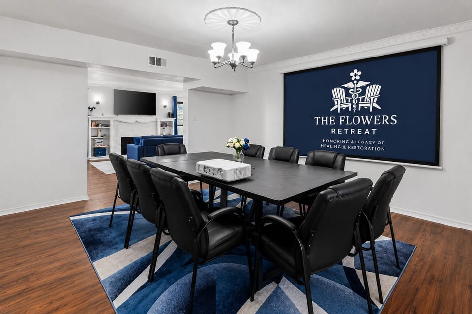 Spacious dining and meeting area with projector and open living room view
