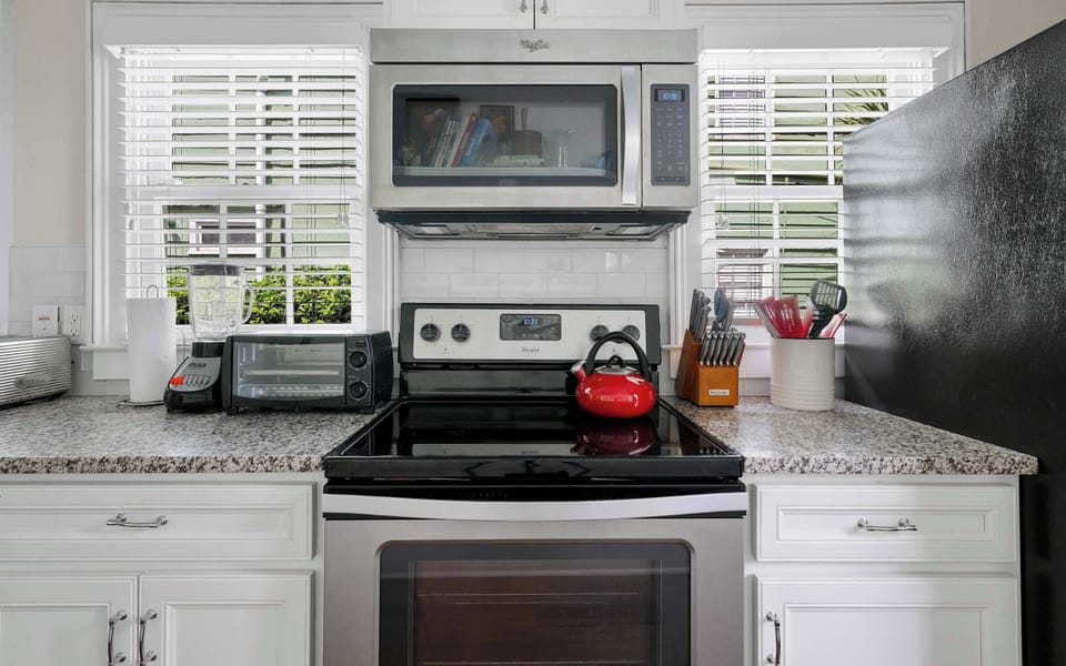 Fully equipped kitchen stocked with modern appliances, cookware, and complete diningware.
