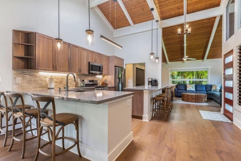Lani Oasis’ chef-ready kitchen includes stainless steel appliances, a large island with bar seating, and open flow to dining and living spaces.