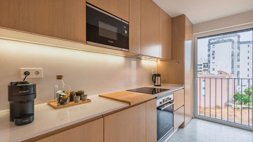 Fully equipped kitchen with sleek appliances, natural wood cabinetry, and morning sunlight to start your day right. #ModernKitchen #NaturalLight #CoffeeCorner