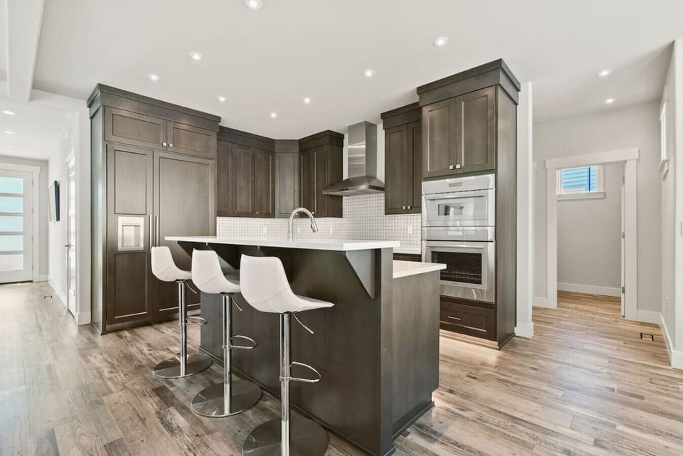 Chef’s dream kitchen featuring sleek Thermador appliances, rich cabinetry, and a spacious island with bar seating — perfect for cooking, entertaining, and gathering together.