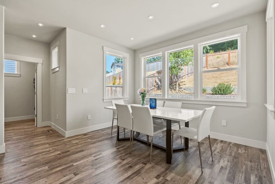 Chic dining area with floor-to-ceiling windows and serene hillside views — a bright space to share meals and conversation.