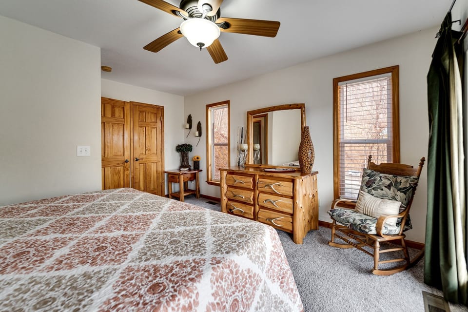 Bedroom with king bed, dresser, and seating area at Dream Weaver cabin near the Nantahala River.