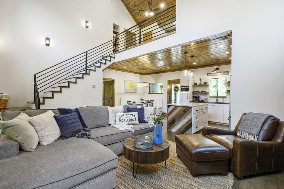 Open-concept living room with fireplace and stylish kitchen view—perfect for relaxing or entertaining.