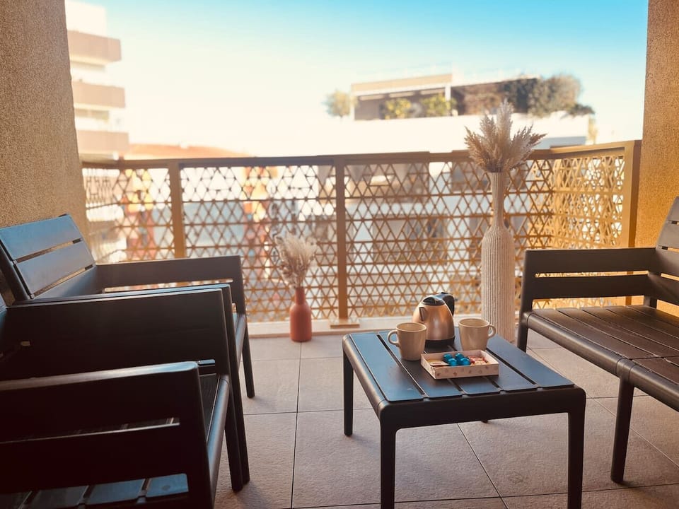La terrasse, aménagée avec des chaises et une table basse, offre un cadre parfait pour se détendre tout en profitant d’une belle vue, idéale pour des moments de relaxation ou des repas en plein airLm sud Conciergerie Montpellier