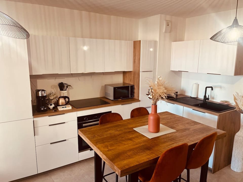Cet espace repas chaleureux et convivial s’intègre parfaitement à la cuisine ouverte, créant un lieu idéal pour partager des repas en famille ou entre amis. Lm sud Conciergerie Montpellier