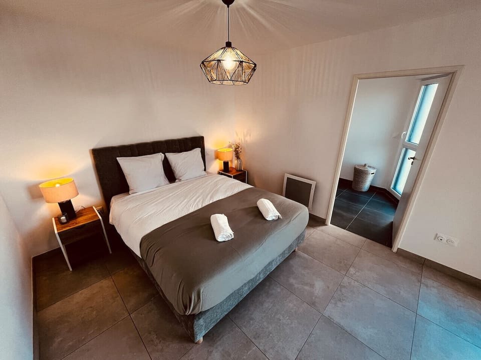 Cette chambre moderne et élégante profite d’une belle luminosité naturelle, mettant en valeur sa décoration épurée et ses tons apaisants.Lm sud Conciergerie Montpellier