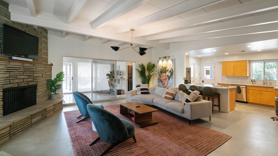 Bright open living space with stone fireplace and stylish kitchen