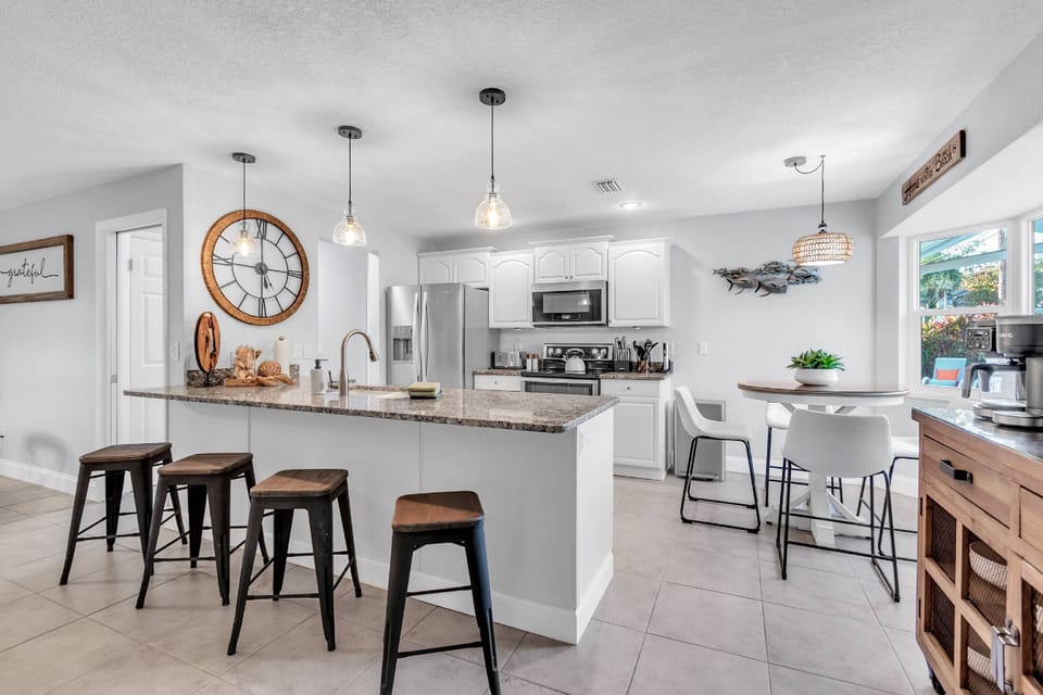 The Kitchen area with bar stools, table seating with a coffee bar on the right.