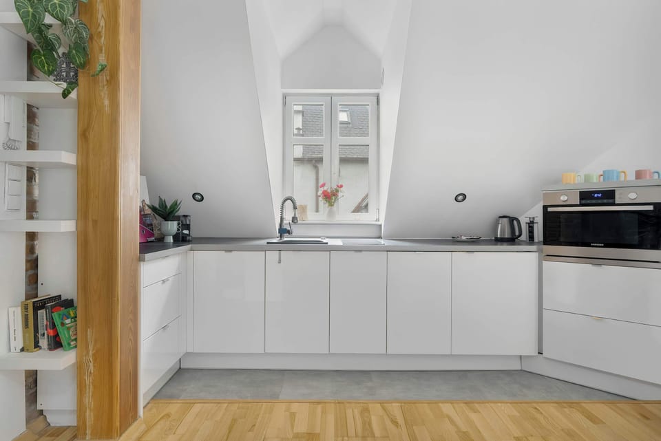 The kitchen is modern and functional, with sleek white cabinetry and a clean, timeless design.
