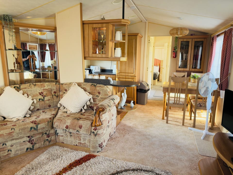 Bright open layout with dining table, kitchen, and cosy lounge.