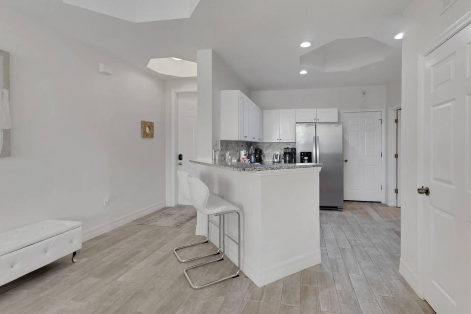 An eating bar with a pair of barstools separates the open kitchen from the main living area.