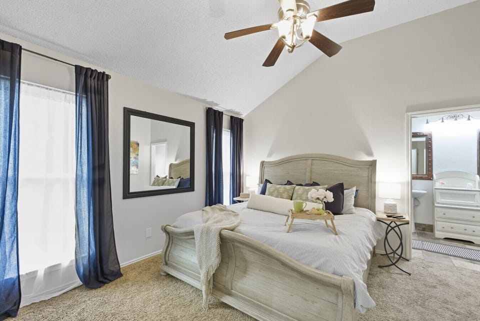 Bedroom 1 | King Bed with Decorative Pillows | Light Wood Sleigh Bed Frame | TV