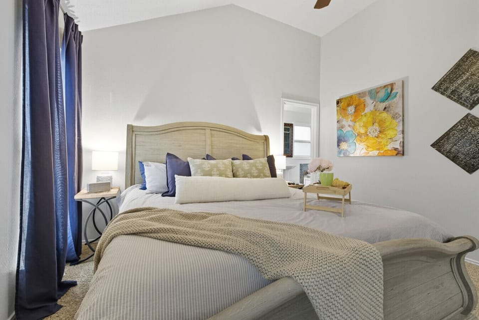 Bedroom 1 | King Bed with Decorative Pillows | Light Wood Sleigh Bed Frame | TV